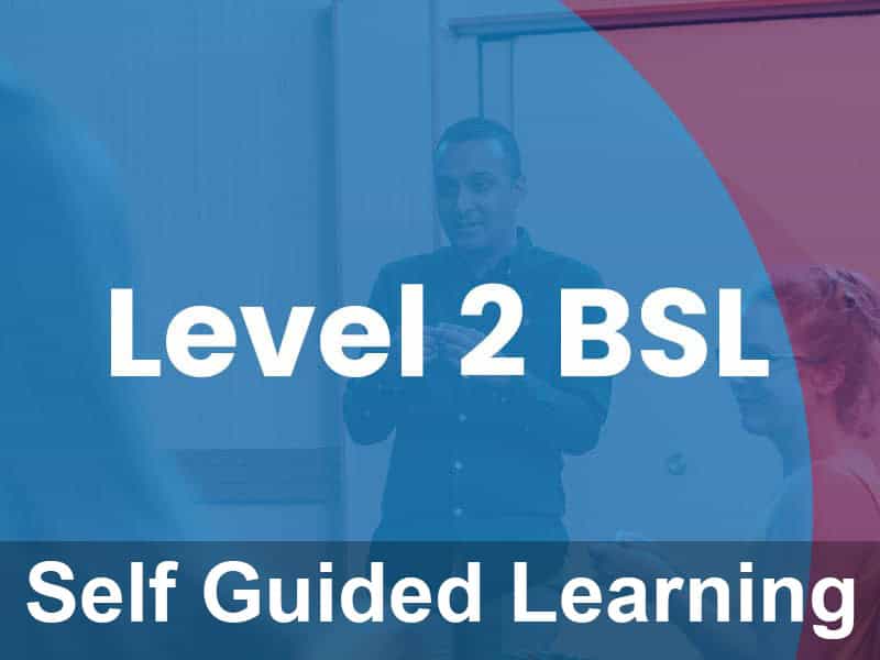 A man stands and gestures with his hands in front of a group. Text reads "Level 2 BSL Self Guided Learning" over a blue and red overlay.